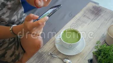 女孩在餐厅或咖啡厅的杯中拍摄抹茶绿茶车床。 纯素健康<strong>饮品</strong>HD慢速运动。 泰国。